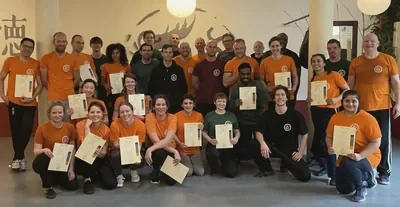 Groep leden van WuDae in de zaal met hun certificaten